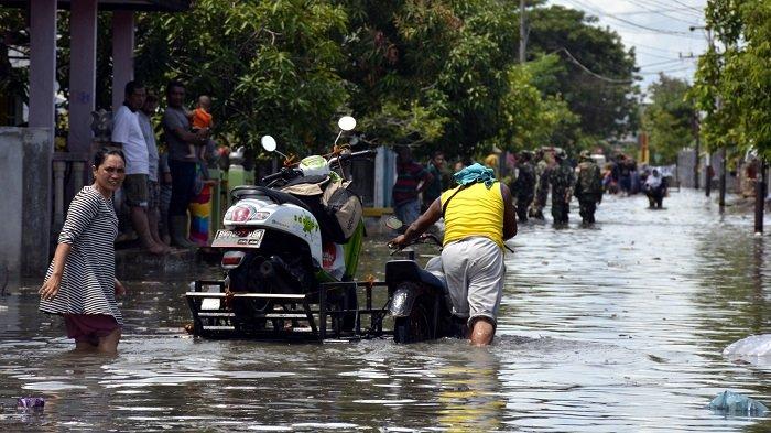 Warga Mengevakuasi kendaaraan Karena Banjir Rob